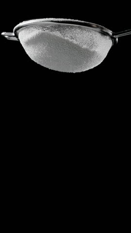 Sift icing sugar or powdered sugar through a sieve tool on black background.