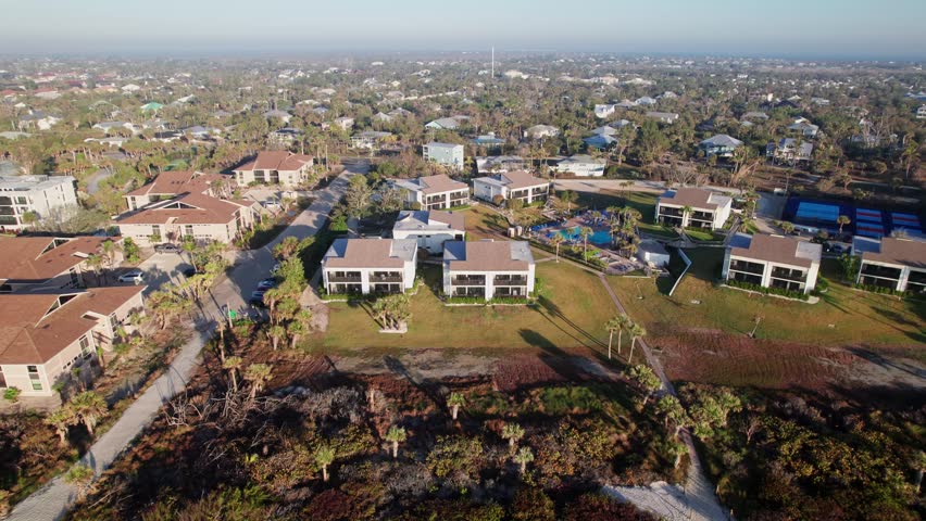 Hotels, rental buildings, resorts, swimming pools, and vacation homes at Sanibel Island, FL from drone aerial in tropical Ocean waterfront and coastline landscape of Florida summer vacationing hotel