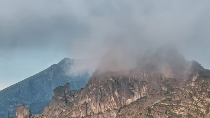 Clouds embracing mountain peaks: a captivating sequence