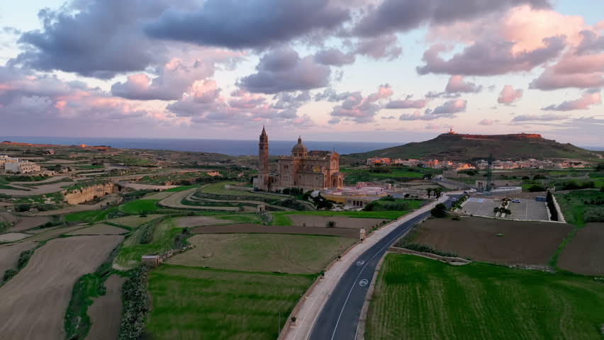 Aerial view of Stunning view of a illuminated Basilica of Our Lady of Ta' Pinu on a hilltop with dramatic sky and landscape. Gozo. Malta