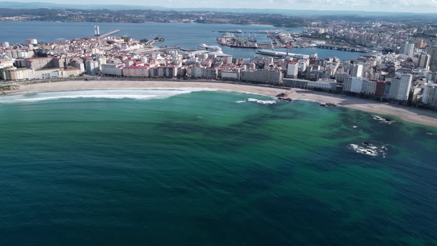 Bautiful panoramic aerial perspective of A Coruna city. Drone going forward above the bay. Old historic center of the city and Port of A Coruna. Orzan Beach. Fanous travel destination in Galicia.