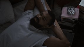 African American man reclines on bed staring contemplatively at ceiling. Black guy embodies period of introspection feeling lost in negative thoughts - Powered by Shutterstock - Get 15% off with code: PIKWIZARD15