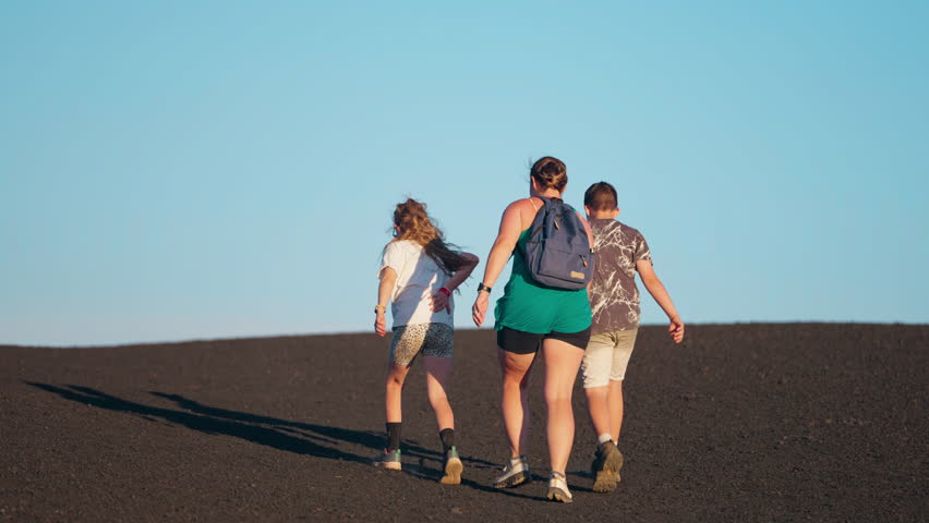 A family engages in outdoor pursuits, exploring the wilderness together as the evening sun casts a warm, golden glow over the landscape.