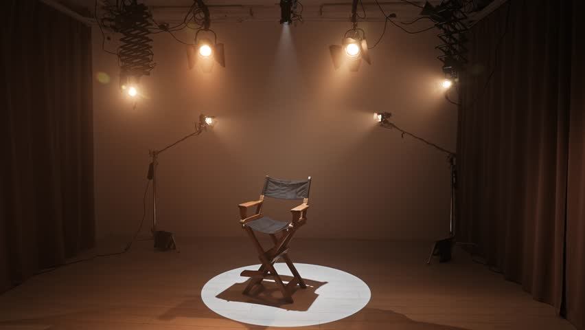 Studio for photo video production filming with lighting equipment and cyclorama, director chair standing in the middle under bright spotlight.