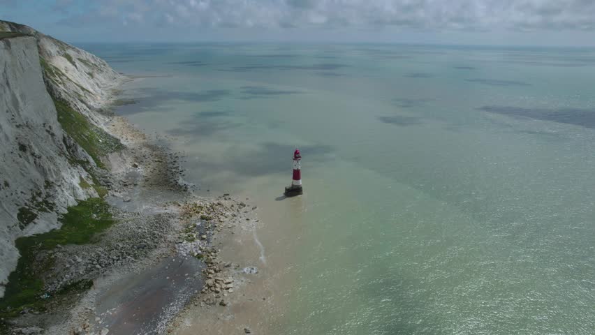 The drone aerial footage of lighthouse and white cliffs at Beachy Head, East Sussex, England. Beachy Head is a chalk headland in East Sussex.