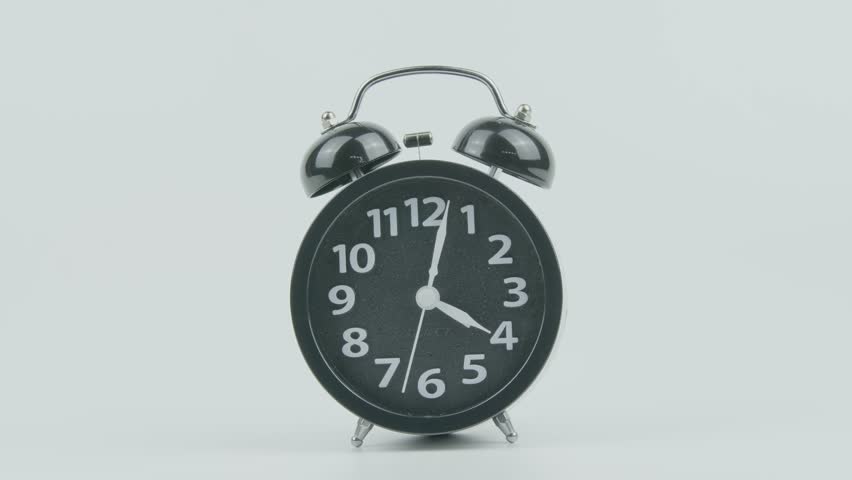 Close-Up of Black Analog Alarm Clock Ringing at 4 AM, Noon, or Midnight on White Background – Time Concept, Wake-Up Routine, and Clock Sound for Morning, Evening, and Daily Life Footage