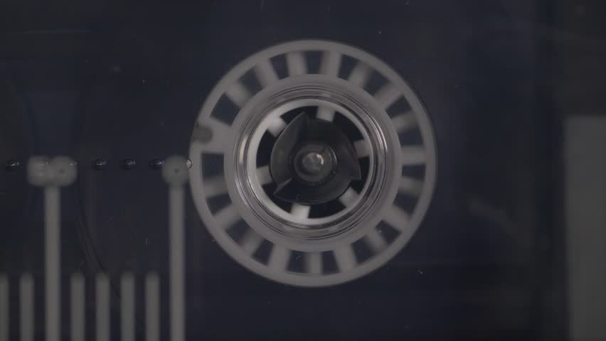 Close-up of a vintage audio cassette tape playing and rotating