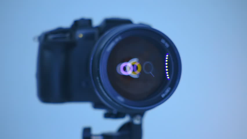 A professional camera on a tripod with an expensive lens with an aperture of 1.5 and a focal length of 85 mm, which reflects the ring LED light. Closeup. Macro