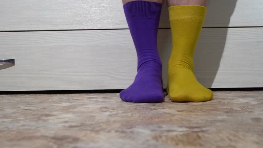 4k. Two different socks on men's feet. Day of Bright Socks, Day of Weird Socks against bullying.