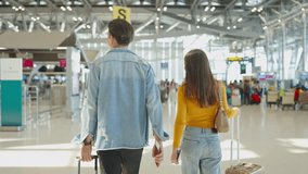 Rear view of young couple walking in airport terminal to boarding gate. Attractive man and woman friends passengers feel happy and excited for going travel abroad by airplane for holiday vacation trip - Powered by Shutterstock - Get 15% off with code: PIKWIZARD15