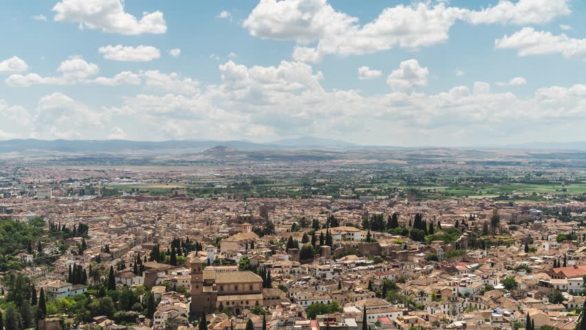 Clouds moving over granada cityscape in andalusia, spain. This timelapse showcases the beauty of the city and its surroundings