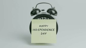 Happy Independence Day Text or Word on Yellow Note Paper Sticking onto Black Alarm Clock on White Background With Sound - Powered by Shutterstock - Get 15% off with code: PIKWIZARD15