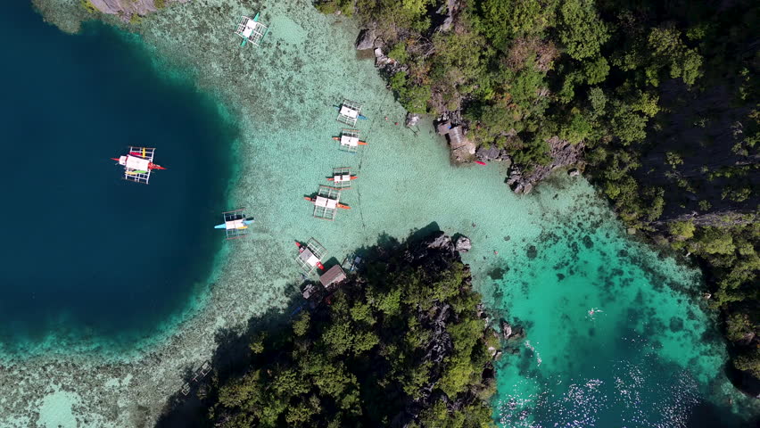 Drone view of Philippines, Coron Island’s untouched coastline, surrounded by clear ocean waters. Aerial view of boats Vertical video.