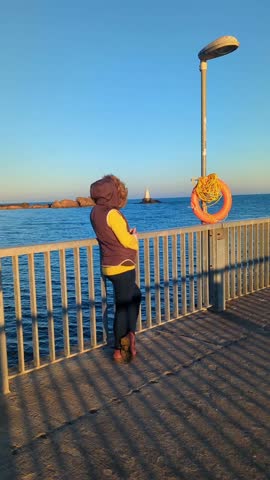A person walking along the seaside promenade in Ahtopol, Bulgaria, in winter.
