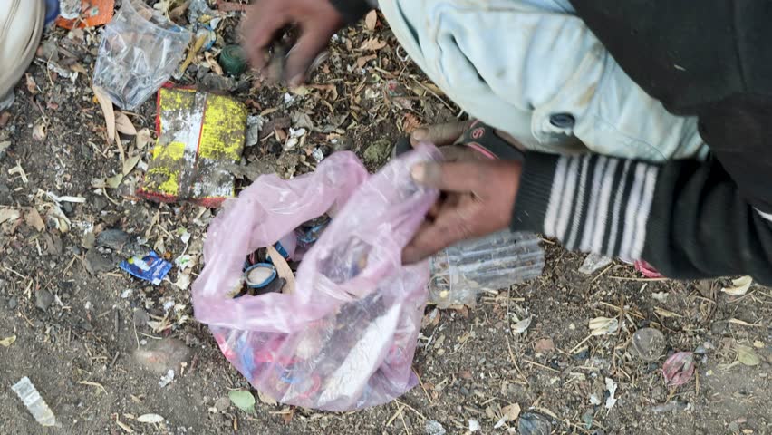poverty stricken children collecting bottle iron caps for recycle and sale at day