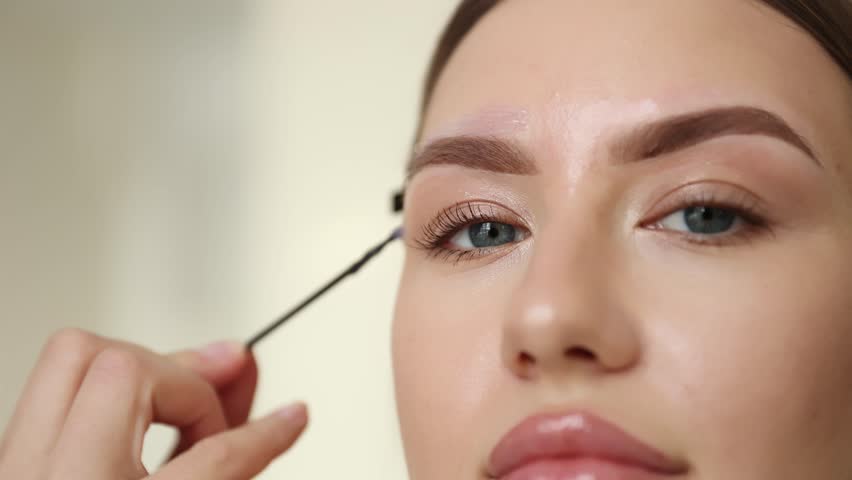 Brow grooming process: eyebrow correction with wax, removal of excess hairs.