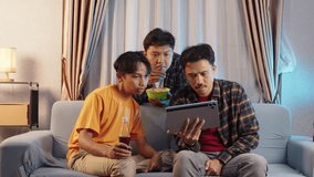 Three friends watching sports event on tablet in cozy living room. Expressive celebration and excitement for favorite team goal. Sports streaming, tablet watching, goal reaction, celebration - Powered by Shutterstock - Get 15% off with code: PIKWIZARD15