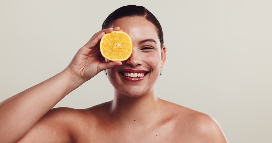 Girl, orange or playful in studio for skincare, natural treatment or vitamin C. Woman, citrus fruit and goofy on white background for organic care, healthy skin and antioxidants for facial protection