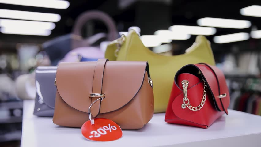 A variety of fashionable handbags showcased on a discount table, highlighting a 30 percent sale. Assorted Stylish Handbags Displayed on a Sale in a Modern Retail Store