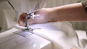 close-up of female hands working on a sewing machine. she carefully watches the work of the sewing machine and the evenness of the stitch, seam. the woman skillfully works on a sewing machine - Powered by Shutterstock - Get 15% off with code: PIKWIZARD15