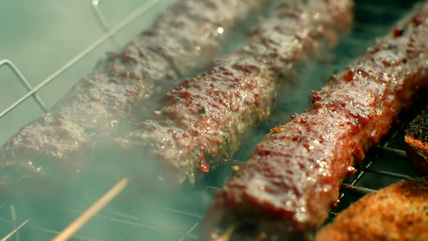 Turkish Cuisine Charcoal Grill Lamb Charred Meat. Culinary Traditional Smoky Barbeque Adana Kebab. Roasted Halal Shish Meat. Cook Roasts Shish Kebab Barbecue On Grill. Arabic Food Grilled On Skewers