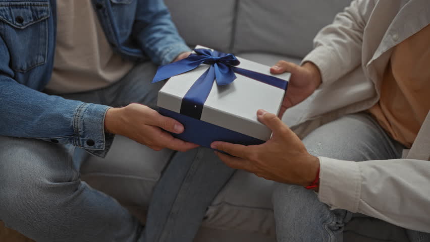 Men exchanging a gift in a living room suggesting a close relationship in a cozy apartment with soft lighting and casual attire
