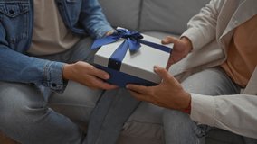 Men exchanging a gift in a living room suggesting a close relationship in a cozy apartment with soft lighting and casual attire - Powered by Shutterstock - Get 15% off with code: PIKWIZARD15