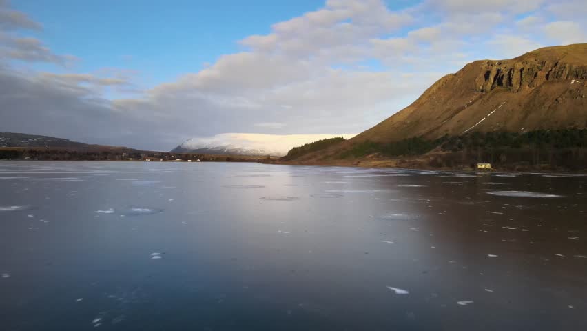 Aerial view of tranquil Hafravatn lake surrounded by majestic mountains under a clear sky, Mosfellsbaer, Iceland.