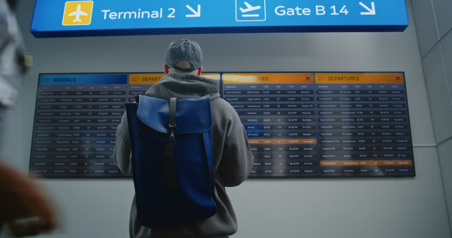 Diverse People and Airport Staff Walking In International Airport Terminal. Passengers with Luggage and Tickets Checking Departures on Digital Departure Board. Flight Information Display For Travelers