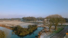 Scenic aerial view of Dutch countryside landscape with frost-covered fields, trees, and small canal winding through. Winter morning light highlights beauty of rural Netherlands. Netherlands, Nederland - Powered by Shutterstock - Get 15% off with code: PIKWIZARD15