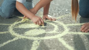 Children drawing chalk on pavement. Kids enjoy creative activity sketching sun. Siblings draw colorful art together pavement. Fun childhood moment as children draw chalk. Pavement kids chalk drawing. - Powered by Shutterstock - Get 15% off with code: PIKWIZARD15