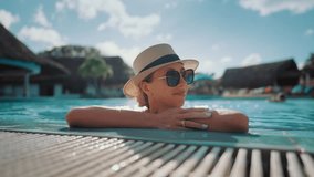 Portrait of pretty woman with sunglasses and summer hat relaxing in open pool. Enjoy summertime and freedom in vacation, holiday trip for rest and recovery vitality, happy lady lying in warm water - Powered by Shutterstock - Get 15% off with code: PIKWIZARD15