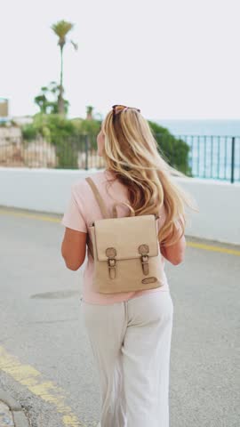 Tourist walking towards the sea in a coastal town