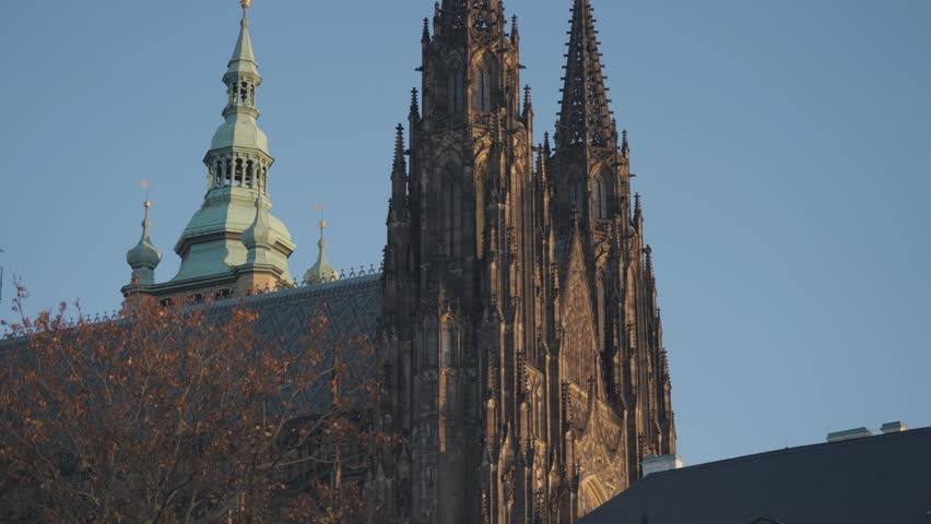 A majestic close-up of St. Vitus Cathedral’s towering spires under a clear blue sky in Prague. Parallax video.