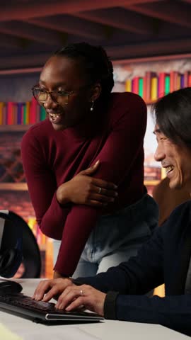 Vertical video Programmer coming to AI startup office CTO manager desk to request help. Employee asks questions to senior team leader in artificial intelligence software development agency, camera B