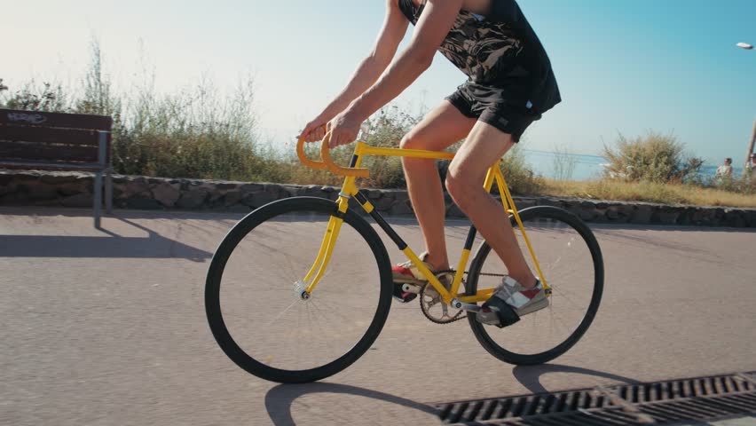 Man ride bicycle near beach in Barcelona, city morning, carbon neutral transportation. Travel, sustainability and cycling with male speed and transit, professional rider training, cardio outdoor sport