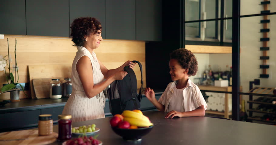 Hug, mother and help child with backpack in kitchen for education support, back to school and morning routine. African family, woman and greeting boy in home for bonding and getting ready to leave