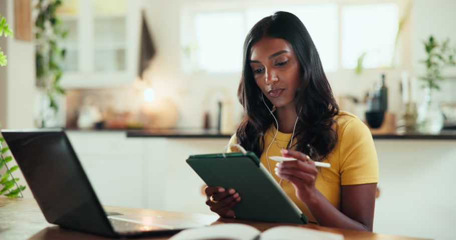 Laptop, music and tablet with web developer woman in home office for design or programming. App, creative and earphones with Indian person at desk in apartment for remote work as freelance designer