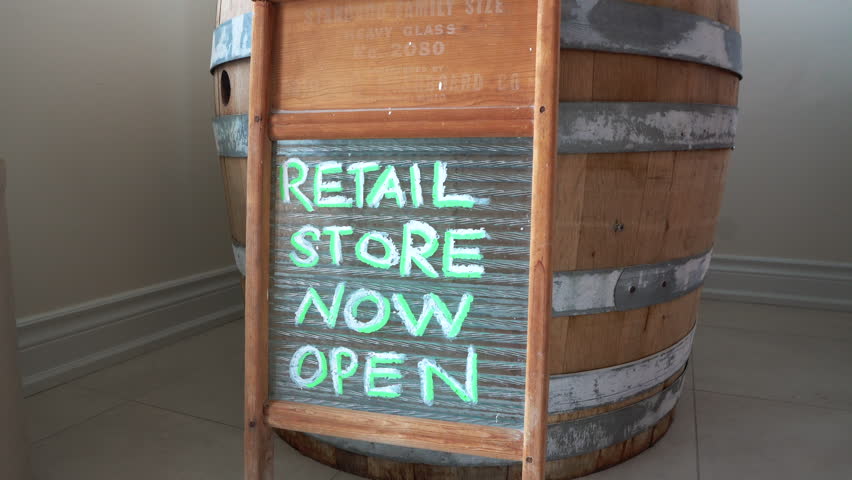 A retail store sign made of an old washboard leaning on an old whiskey barrel
