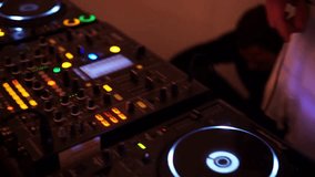 DJ mixer on table at night club EDM DJ working at underground rave pressing buttons moving sliders - Powered by Shutterstock - Get 15% off with code: PIKWIZARD15