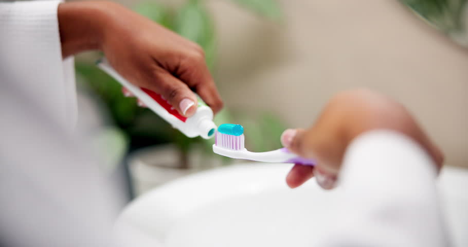Hands, brushing teeth and woman in bathroom, hygiene and morning routine for fresh breath. Closeup, house and person with tooth paste, dental health and oral care with grooming and remove plaque