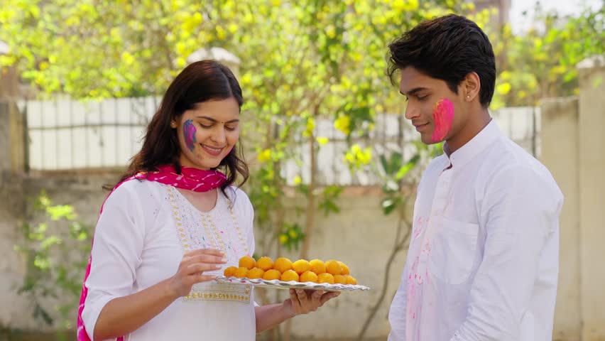 Indian Couple Feeding Sweets to each other on Holi Festival