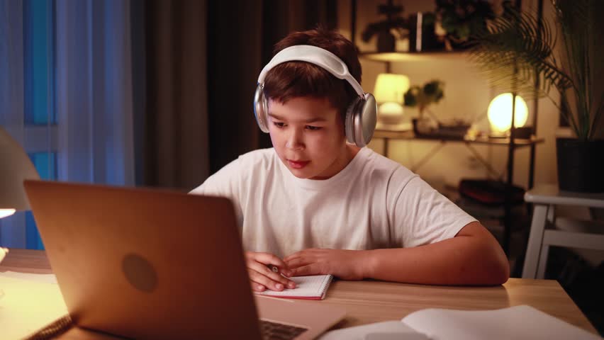 Portrait of cute little boy studying using laptop computer and looking at screen at home Adorable multiethnic kid child doing homework alone late at night indoors Distance online education - Powered by Shutterstock - Get 15% off with code: PIKWIZARD15