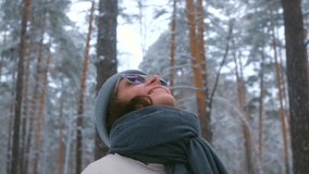 Winter forest solitude with cheerful woman wearing warm accessories, gazing upward while enjoying gentle snowfall amid snow-covered pine trees and serene landscape - Powered by Shutterstock - Get 15% off with code: PIKWIZARD15