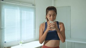 Sporty asian woman drinking milk, flexing powerful biceps while highlighting protein benefits and muscle-building potential for optimal health and fitness performance - Powered by Shutterstock - Get 15% off with code: PIKWIZARD15
