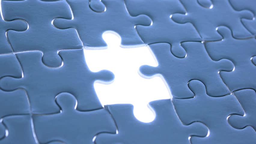 Hand solving and completing the jigsaw puzzle. Business teamwork brainstorming and cooperation concept Hand places piece into puzzle