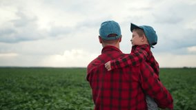 Farmer and child examining soybean field. Father carrying child both in red plaid shirts. Dream farm life. Child learning about agriculture. Father and child bonding examining crops. Dream future farm - Powered by Shutterstock - Get 15% off with code: PIKWIZARD15