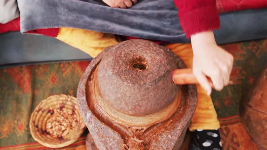 Woman's hands close up producing Argan oil on the factory in Morocco