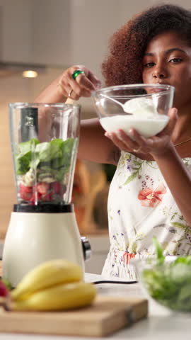 Blender, cream and ingredients with woman in kitchen of home to prepare smoothie for diet. Health, nutrition and recipe with vegetarian person in apartment for cooking, detox or weight loss beverage