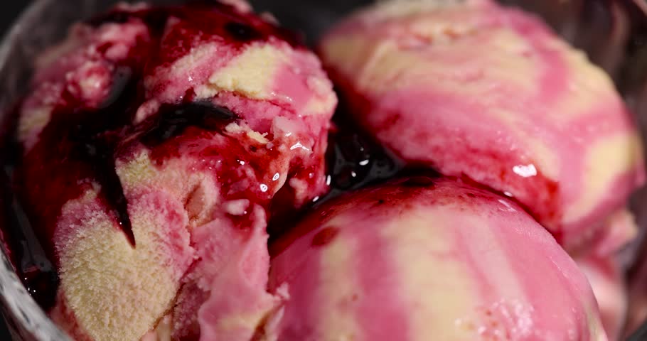 ice cream with raspberry poured with raspberry jam, natural ice cream with different flavors poured with grated berries of fresh raspberries with blackberries close up